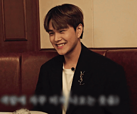 Jahan wearing a suit, grinning widely and laughing