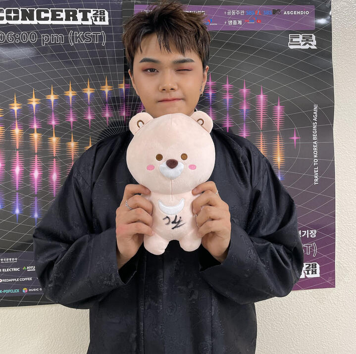 Jahan holding a bear plushie and playfully grimacing