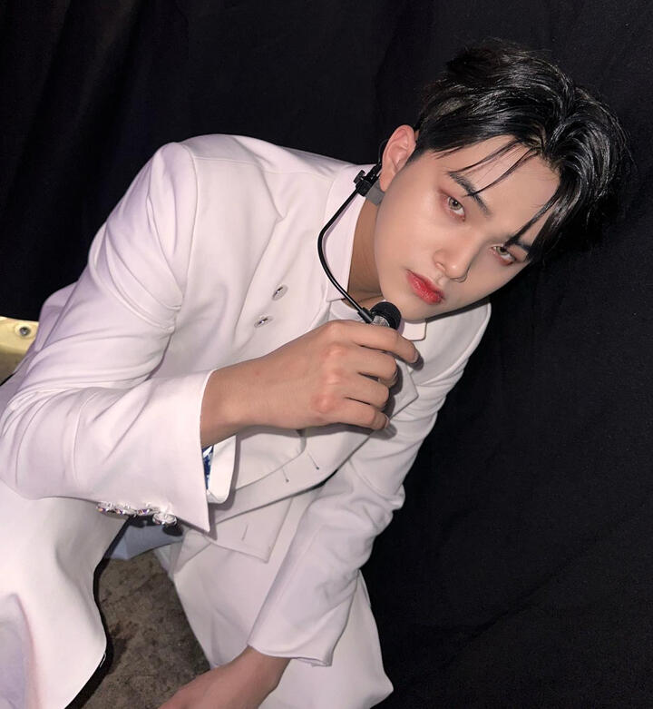 Jahan wearing a white coat and white pants looking up into the camera.